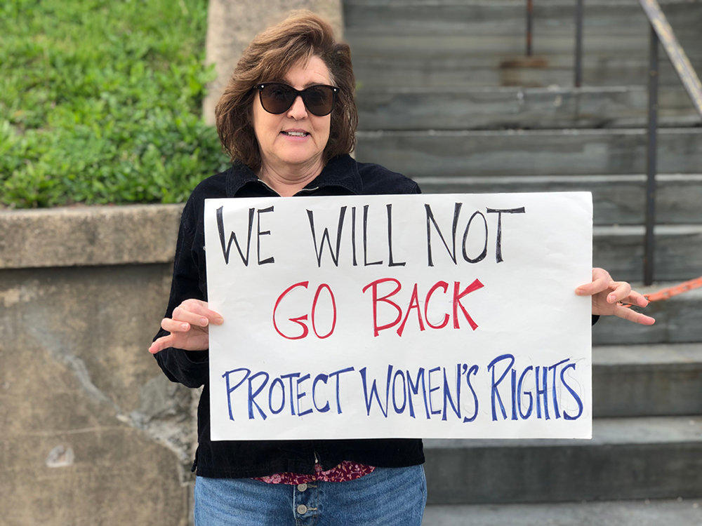 Sandy Walklet with her sign stating the need to protect womens rights.